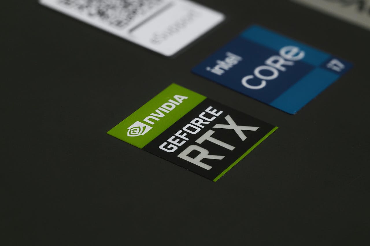 About Close-up of NVIDIA GeForce RTX and Intel Core i7 stickers on a laptop surface, showcasing modern technology.